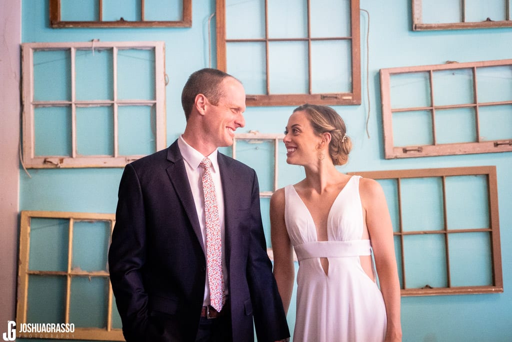 bride and groom in front of window wall at Monday Night Garage Wedding