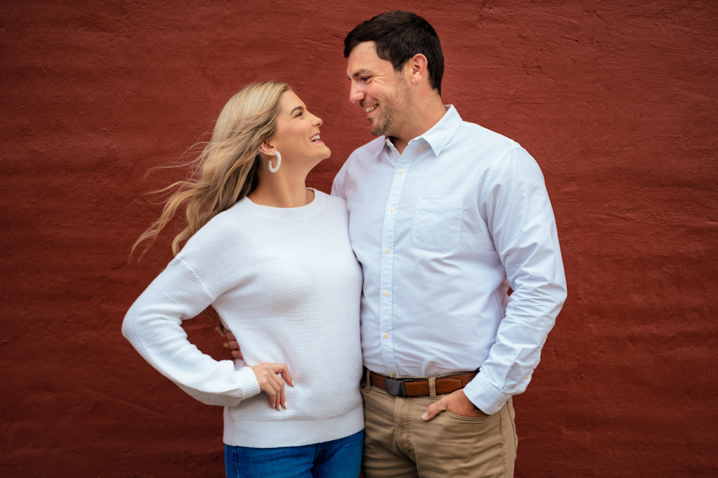 Couple Laughs in the wind during an engagement portrait in downtown ballground georgia